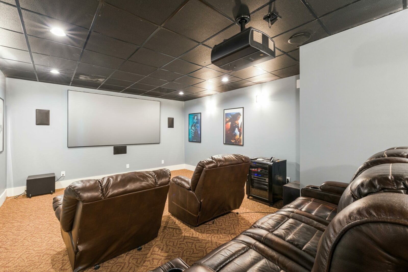 Cozy home theater setup with plush leather recliners and modern audiovisual equipment.